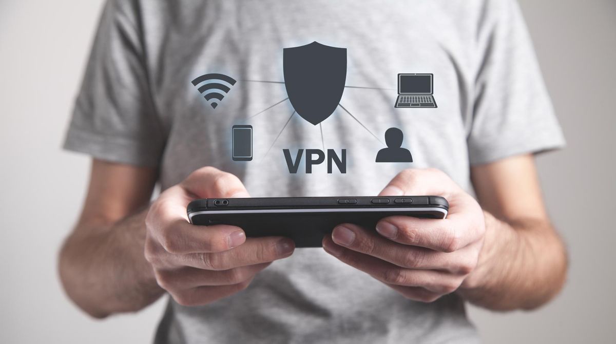 enlarge the image: Mann hält ein Tablet in der Hand über dem die Buchstaben VPN und Piktogramme des IT-Bereichs schweben